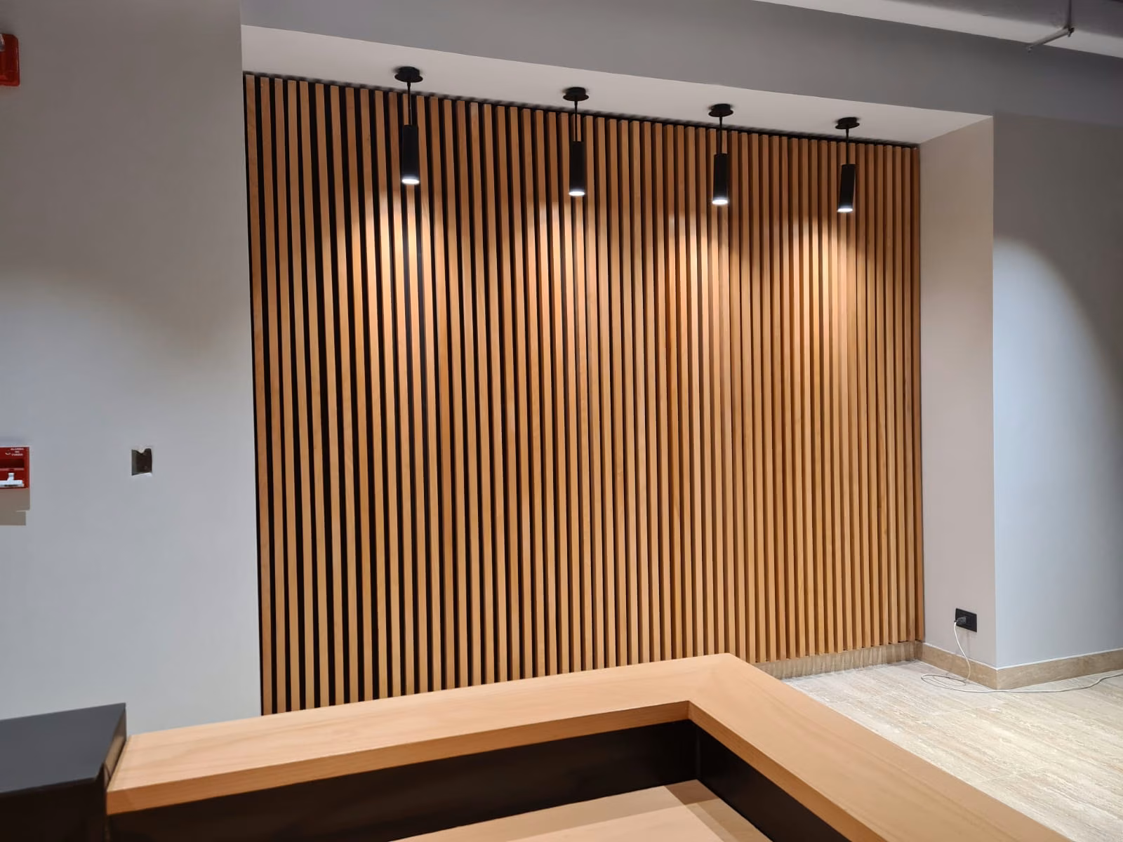 Muro de palillaje vertical de madera nativa con lámparas colgantes, Family Office Providencia