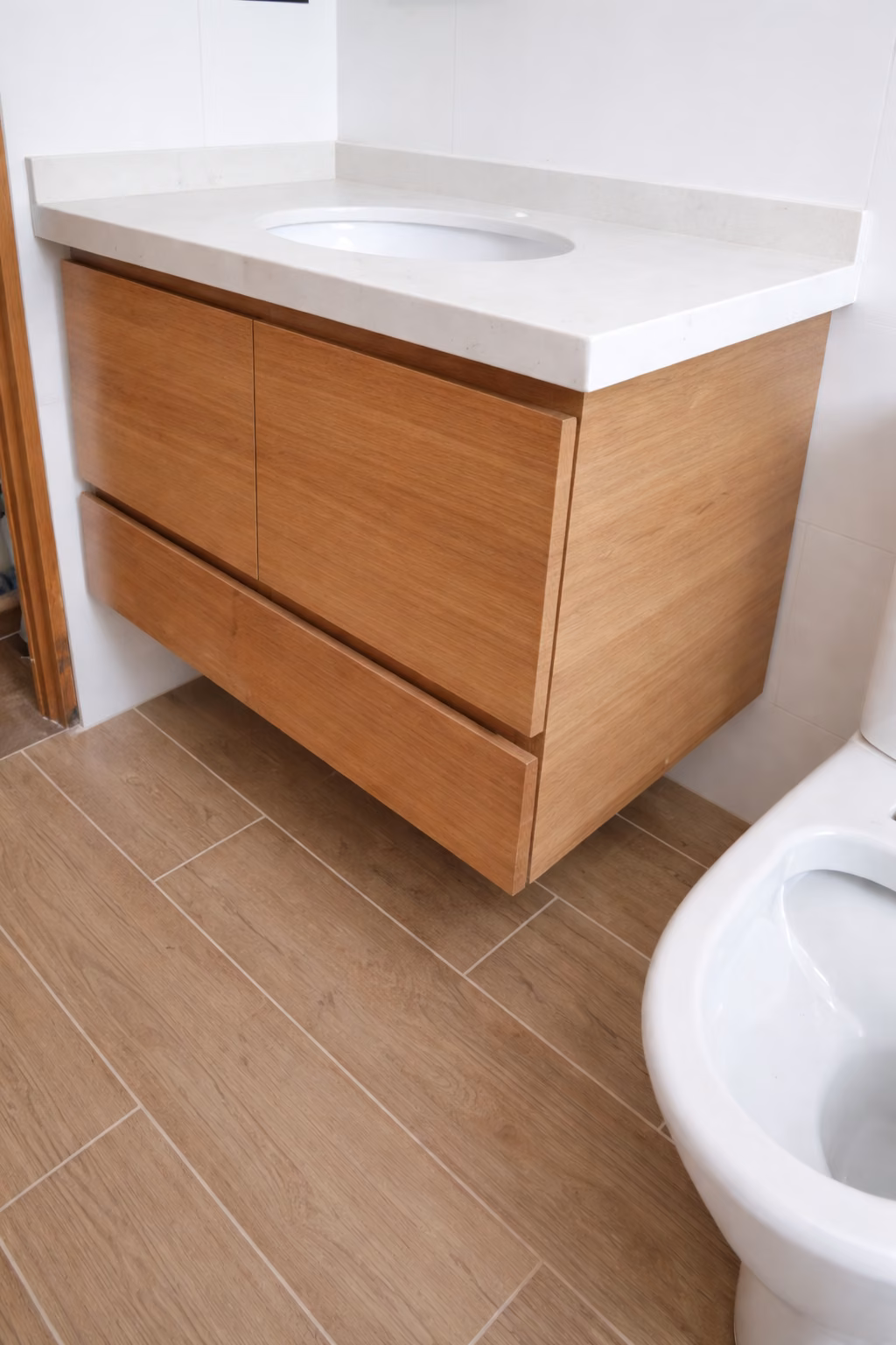 Vanitorio de madera con cubierta blanca en un baño