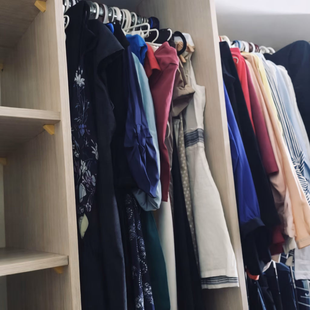 Closet con ropa colgada y repisas