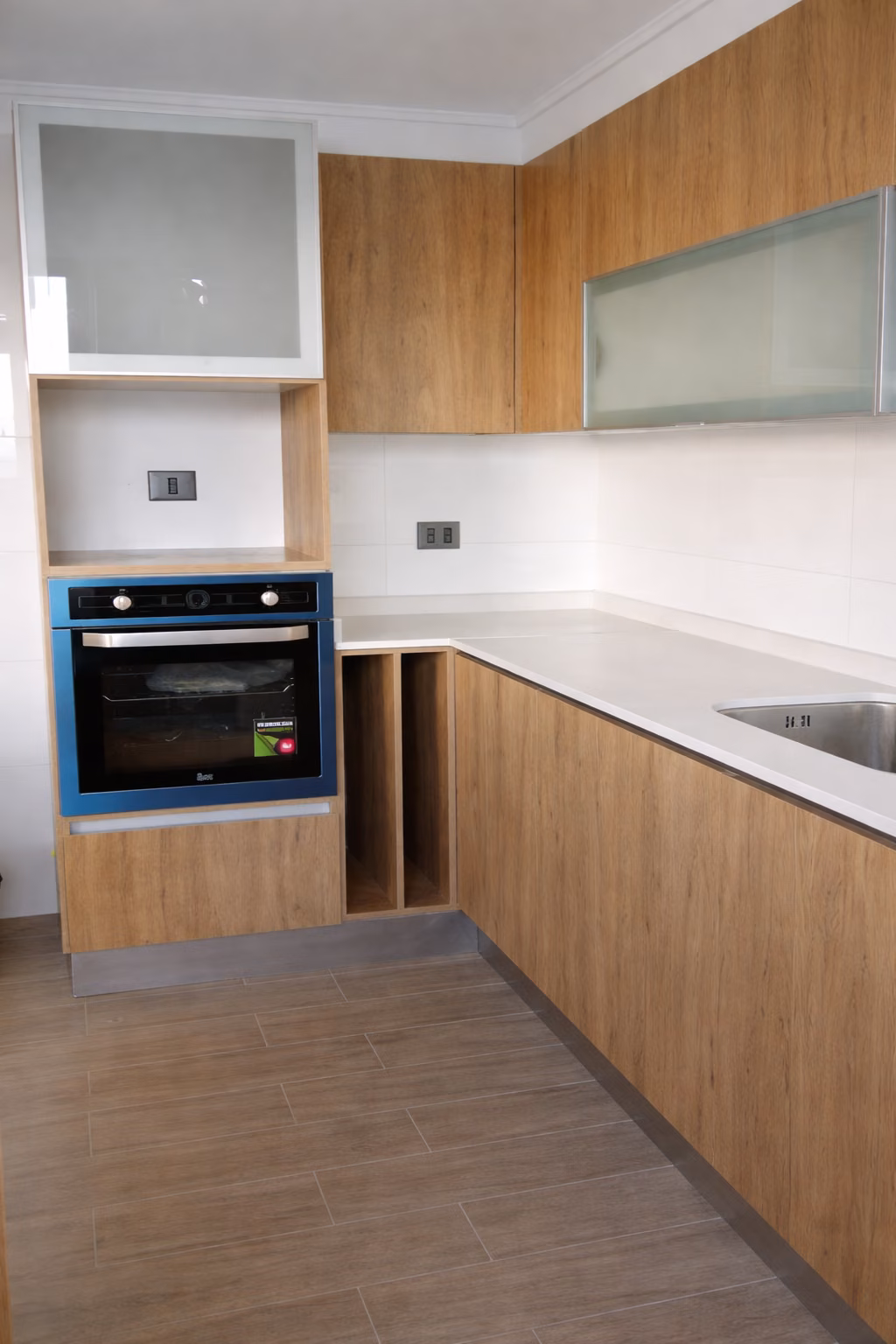 Cocina de muebles de madera y blanco con horno a media altura