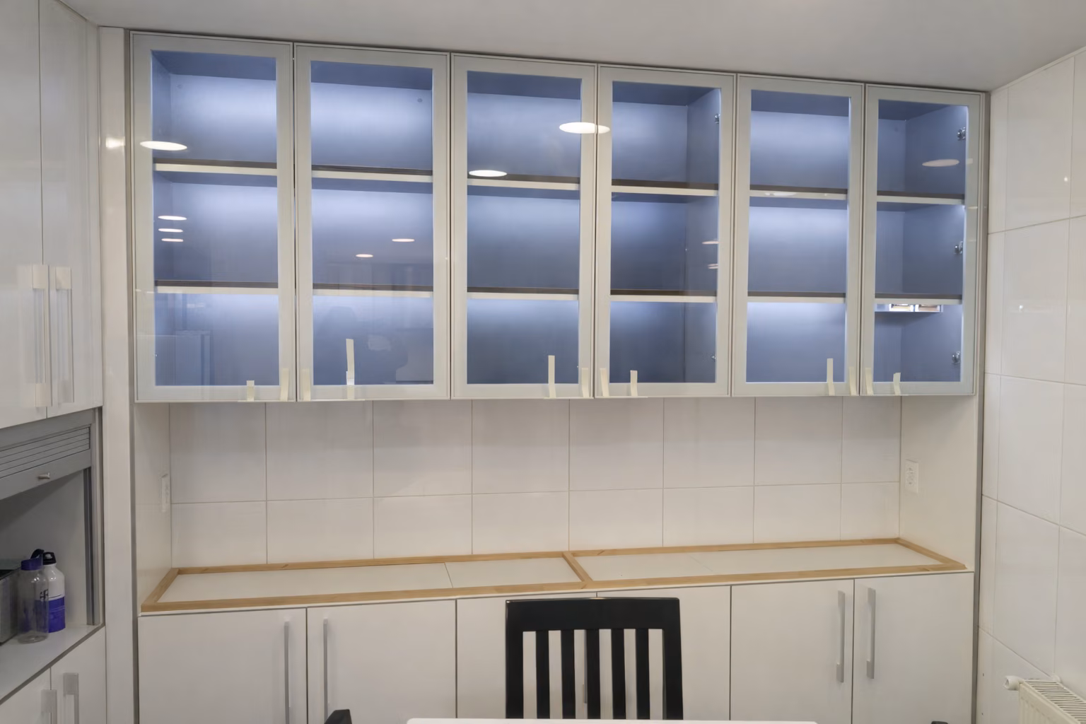 Muebles altos con puertas de vidrio sobre un mesón de laboratorio