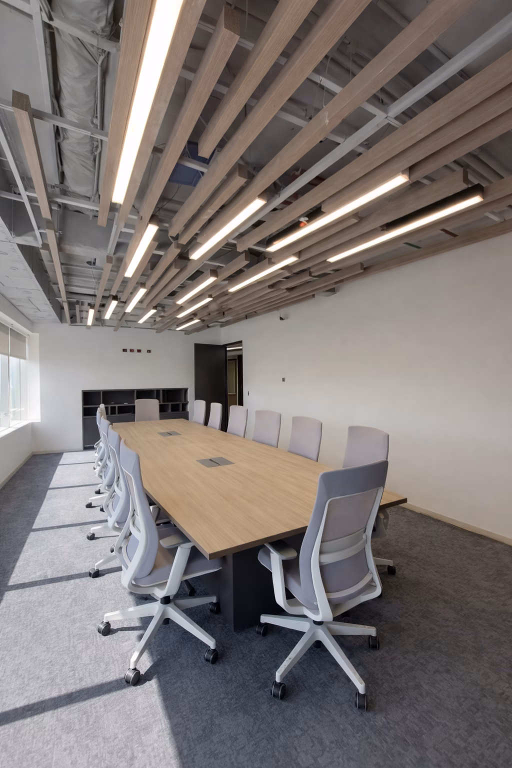 Sala de reunión con mesa larga bajo cielo de palillaje
