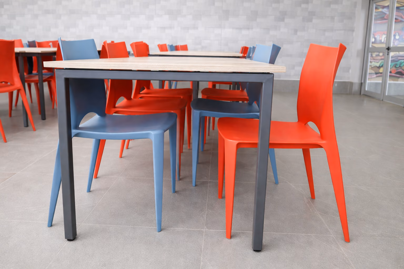 Hileras de mesas con sillas bicolor en el comedor
