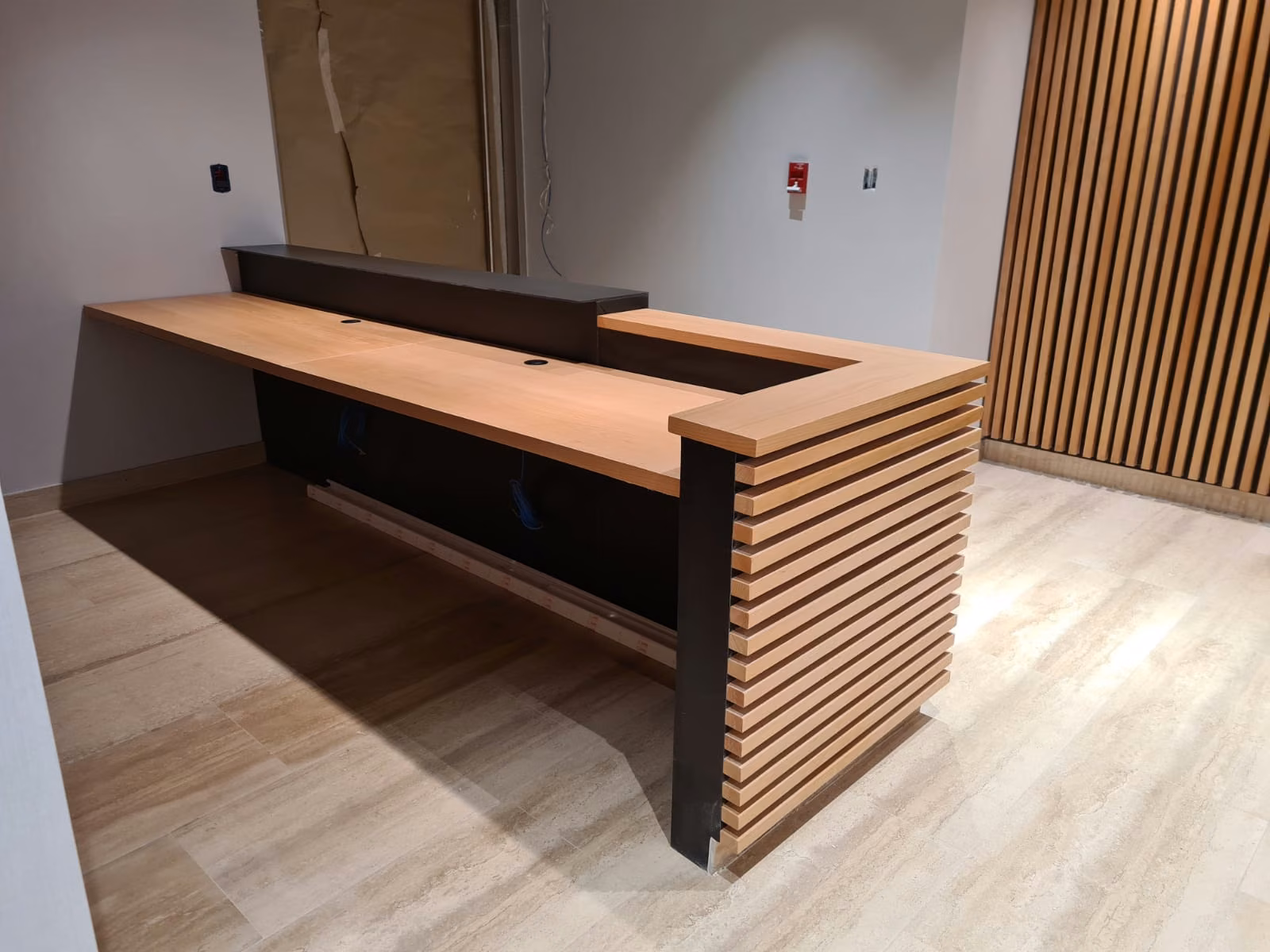 Esquina del mesón de recepción con cubierta de madera y palillaje