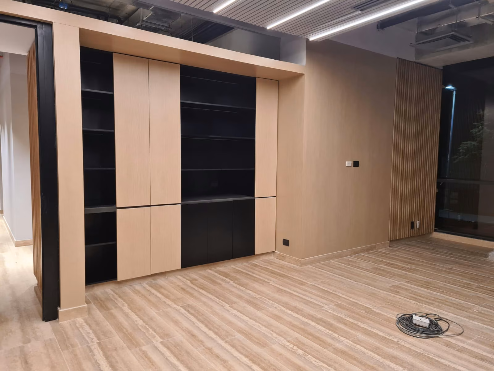 Muebles de guarda empotrados en madera clara con nichos negros