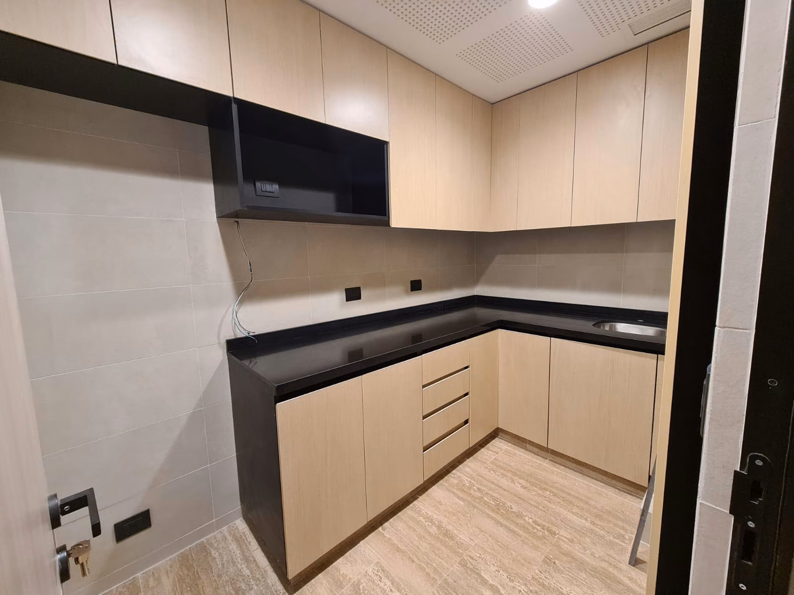 Cocina habilitada con muebles de madera y cubierta clara