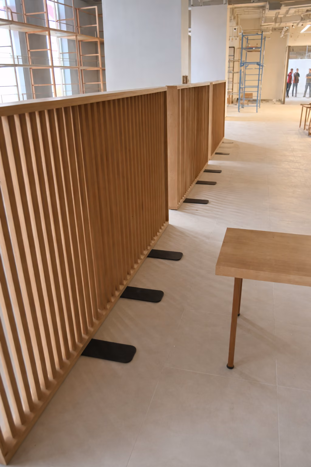 Separador de listones de madera junto a un mesón de apoyo