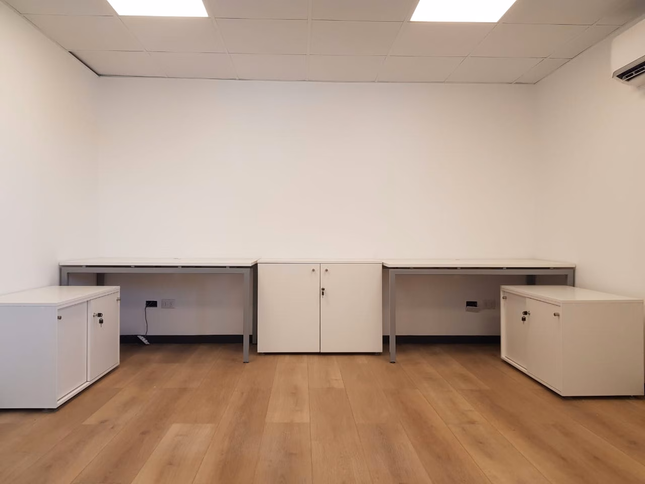 Escritorios bajo ventana en una sala antes de su uso