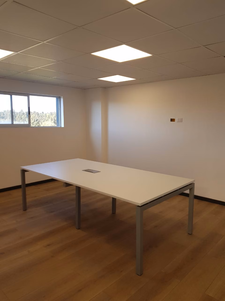 Mesa de reunión en una sala vacía con ventana