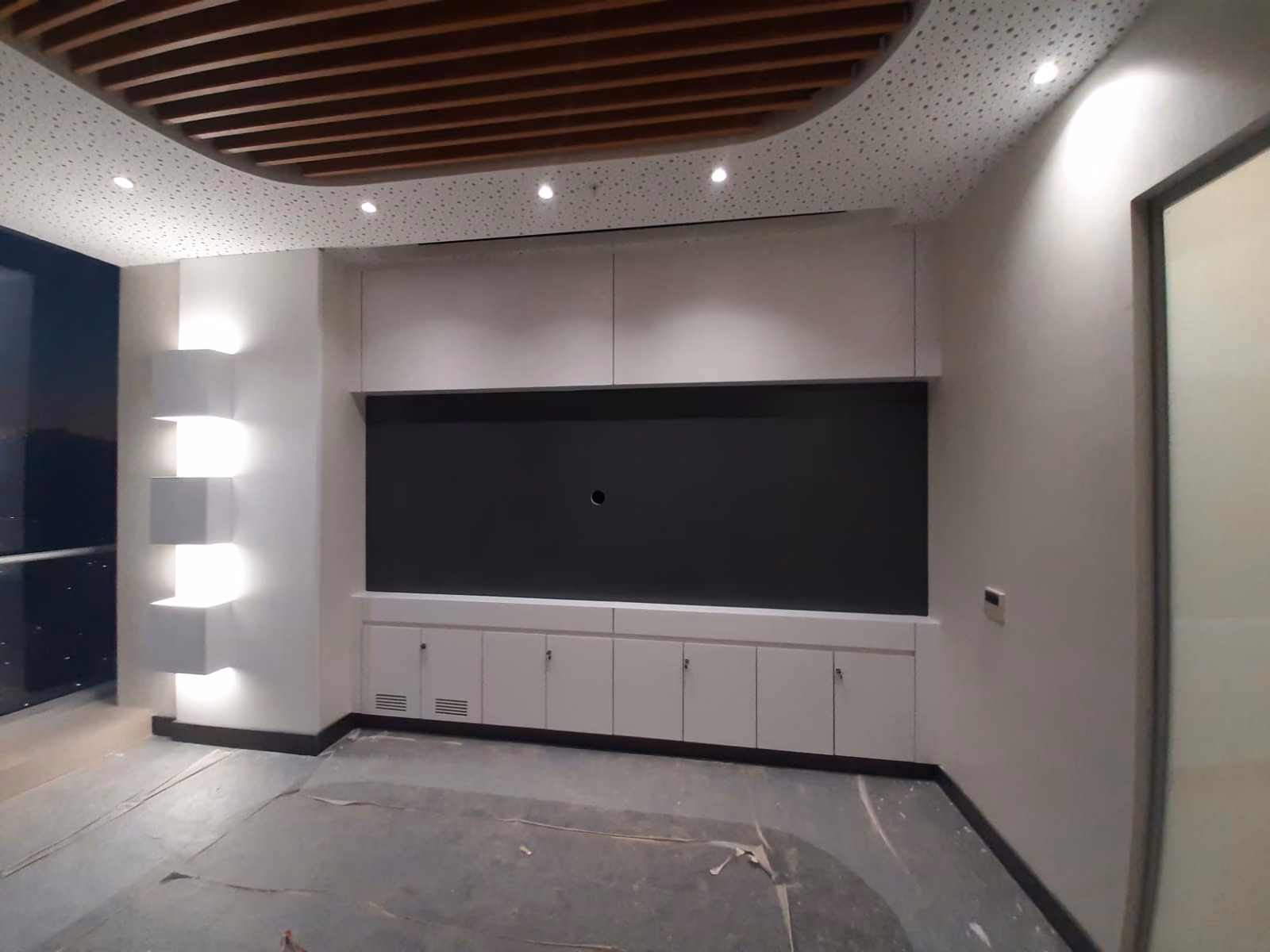 Mueble técnico de sala audiovisual con pantalla empotrada y cielo de madera